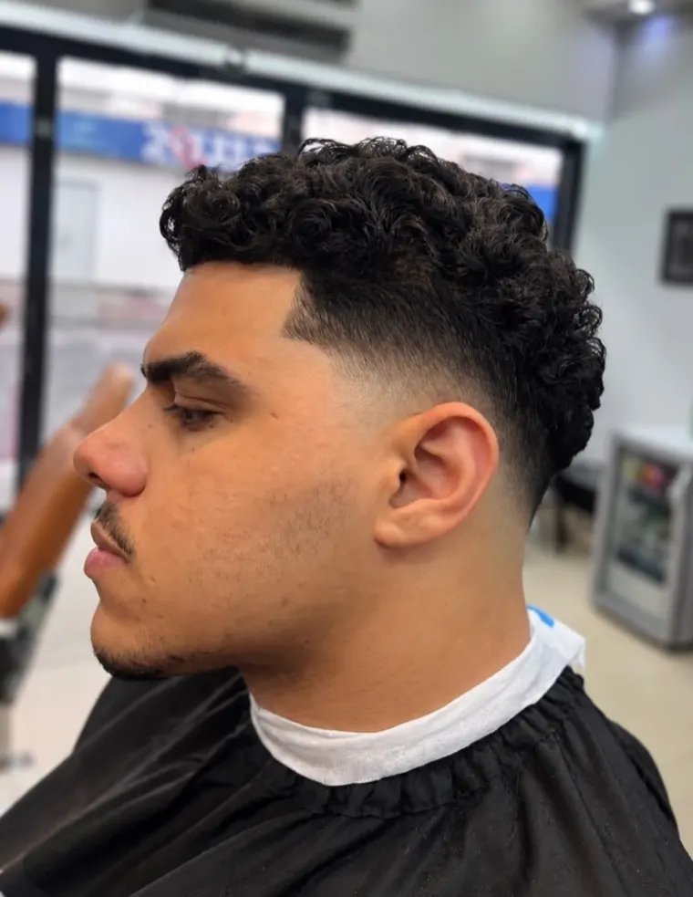 Cliente com cachos e fade limpo